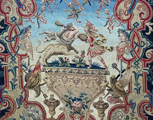 Detail einer historischen Bildwirkerei mit mythologischen Figuren in Rot, Blau und Gold